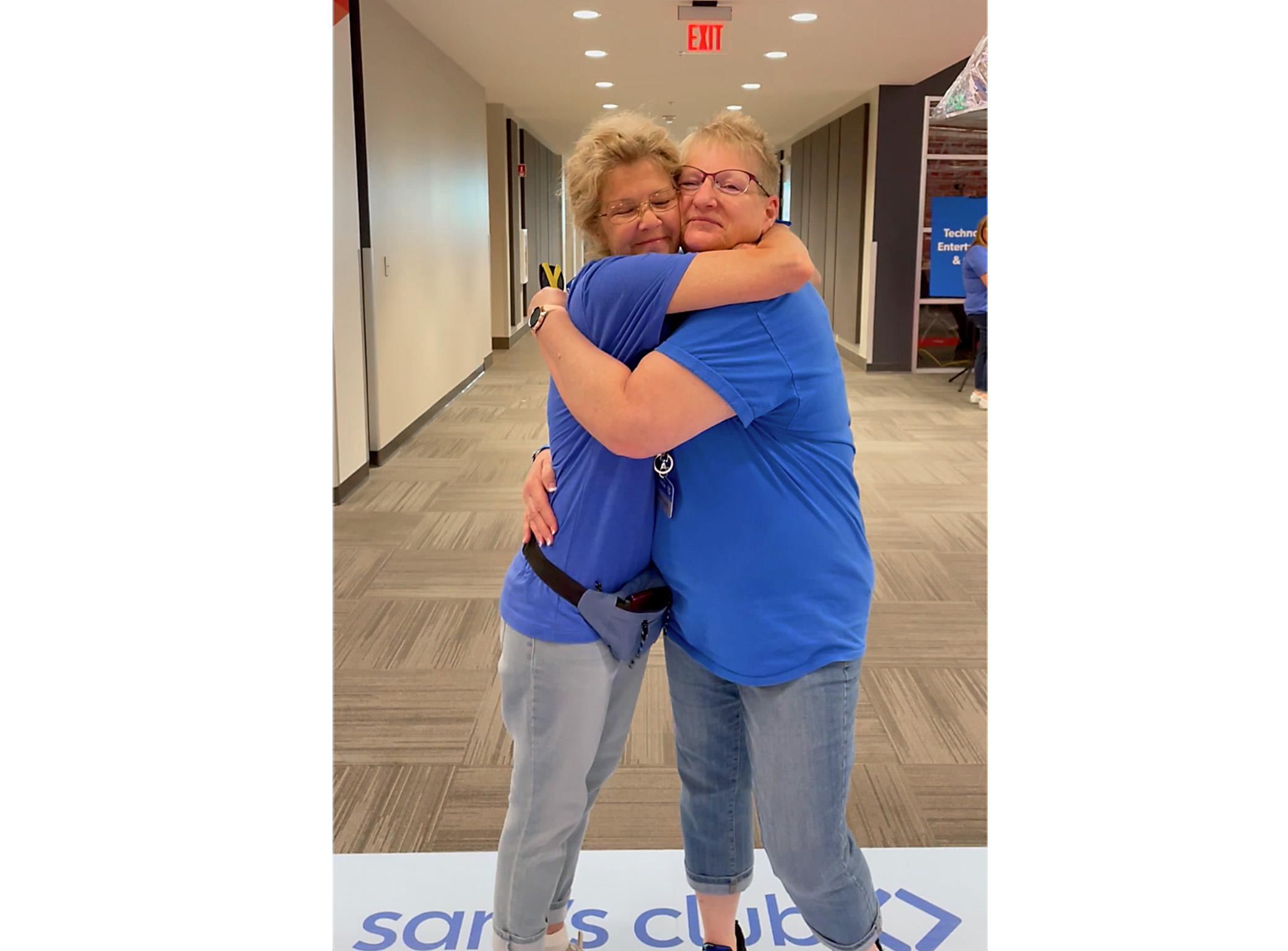 two women hugging and smiling at the camera
