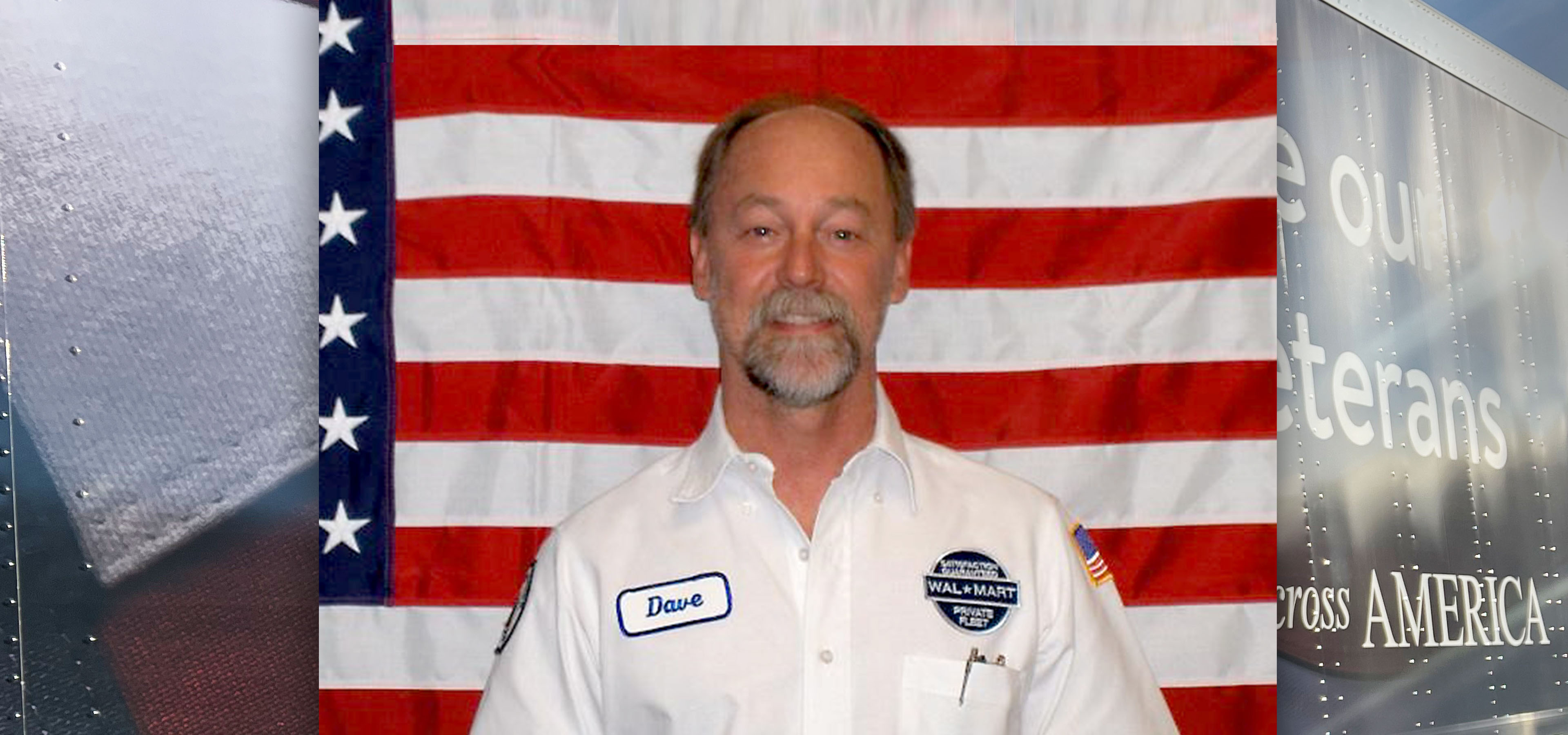 Driver Dave smiling at the camera standing in front of an American flag