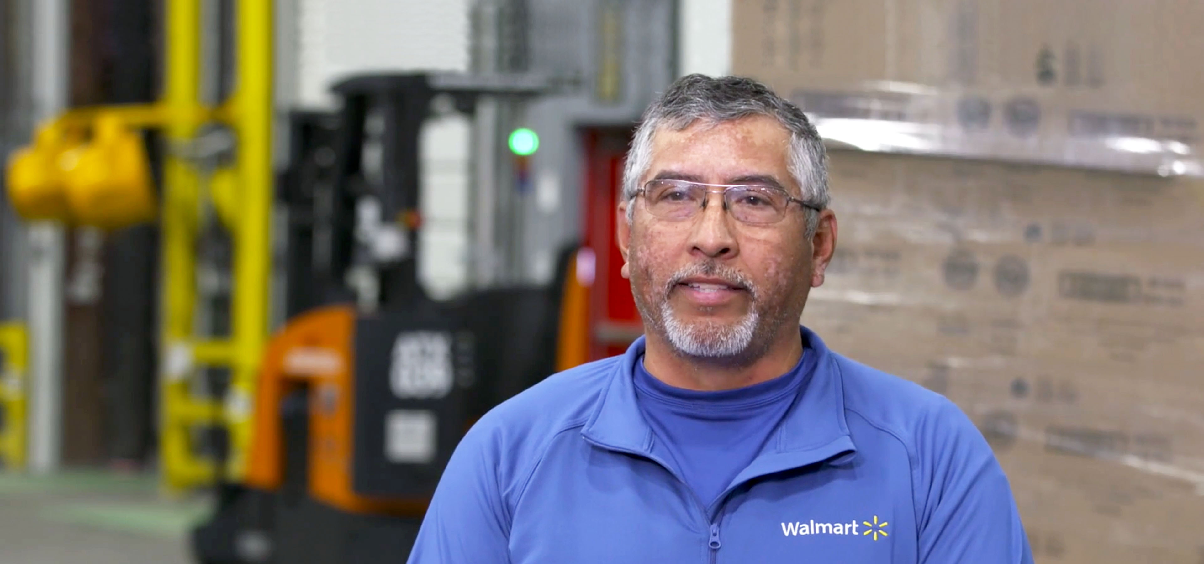 Jose Molina standing smiling at the camera at a fulfillment center