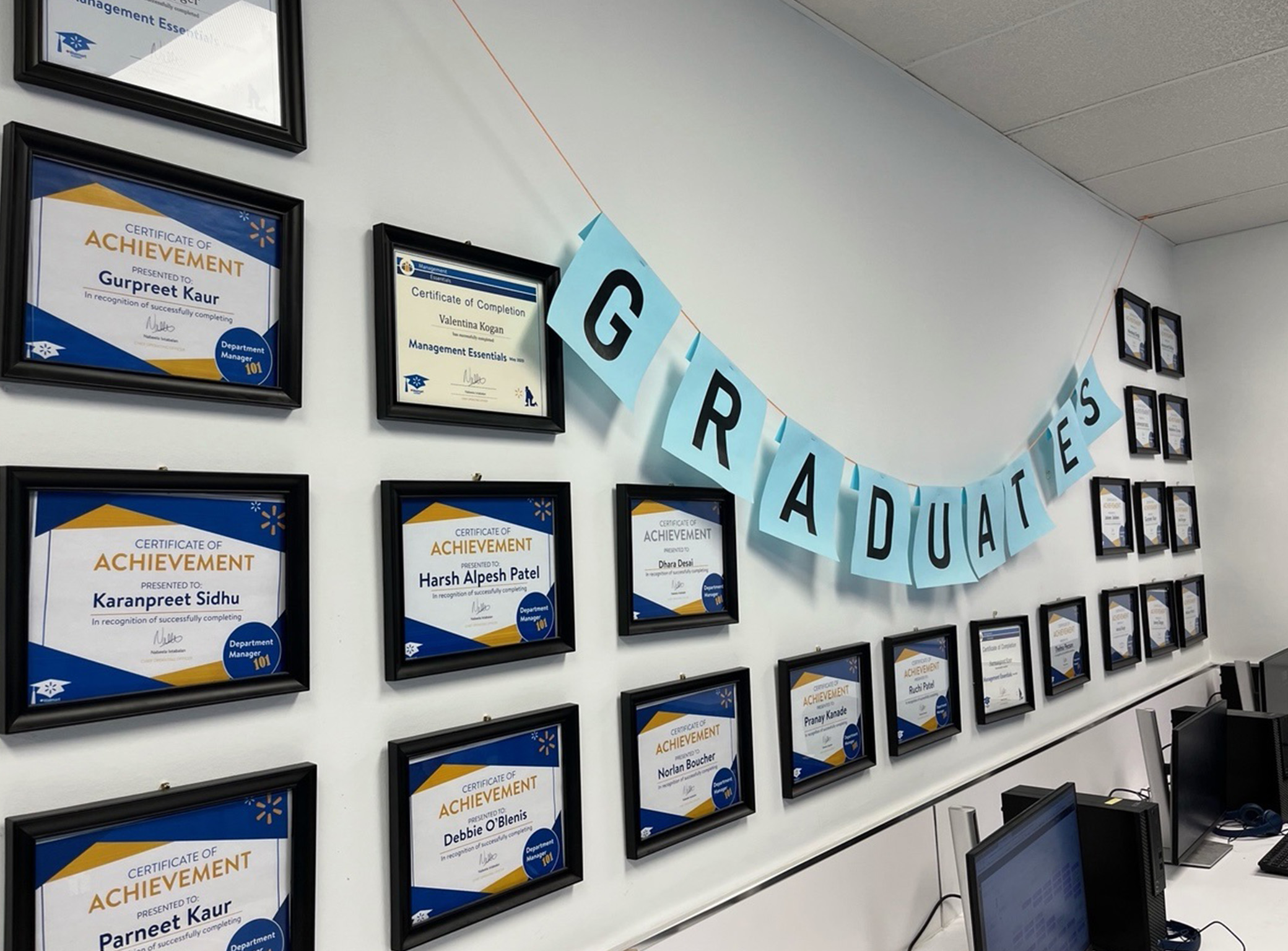 wall with framed diplomas and a graduate banner hanging on the wall