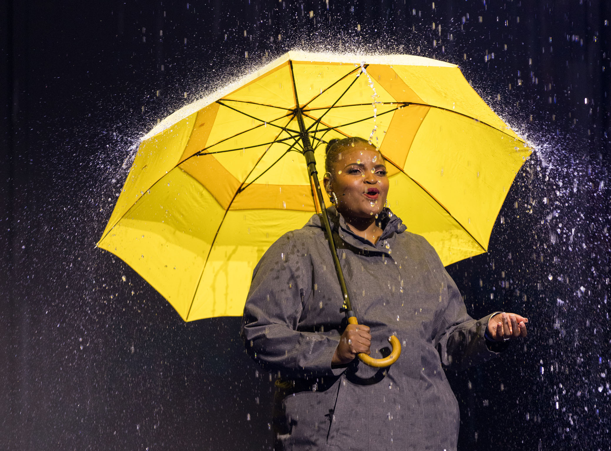 WATs winner on stage holding a yellow umbrella