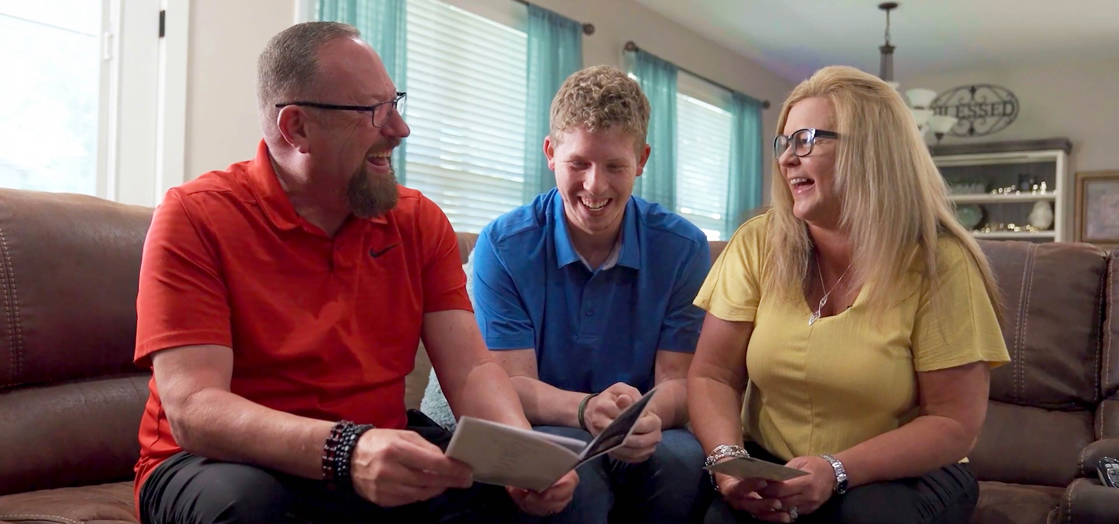 Walmart associates Mark, Conner and Kim Stevens sit together on a couch.