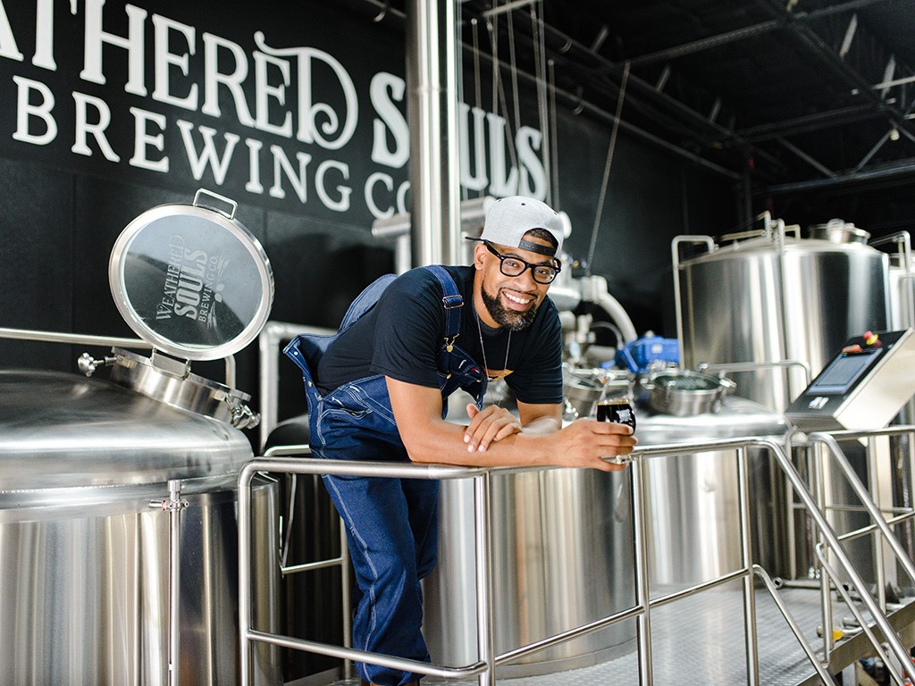 Marcus Baskerville, Weathered Souls’ head brewer and cofounder, stands in front of brewery equipment.