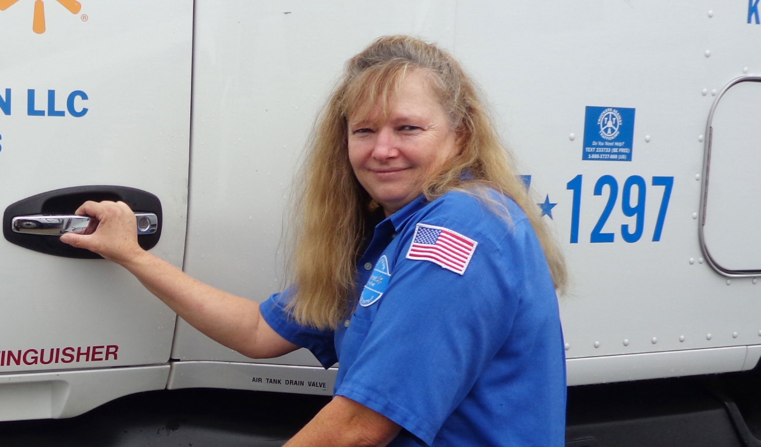 Anita Asbury smiles next to her rig