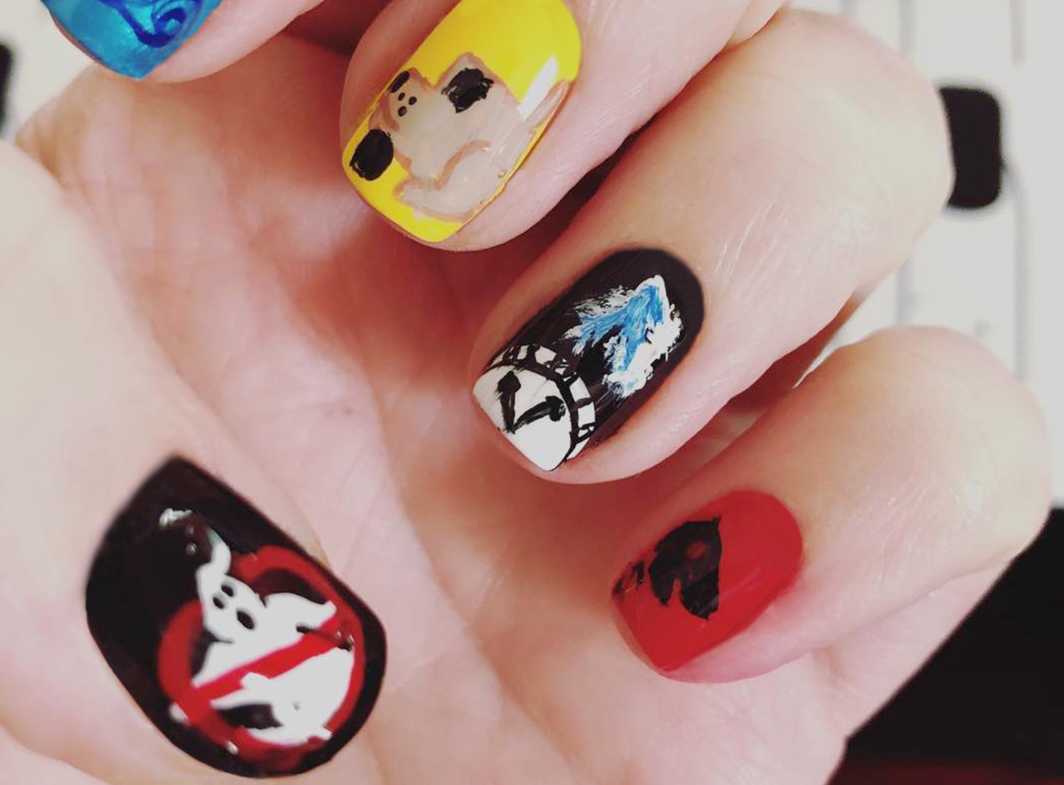 Some of Jenna Sundeen's fingernail masterpieces: Ghostbusters logo, clock, dog.