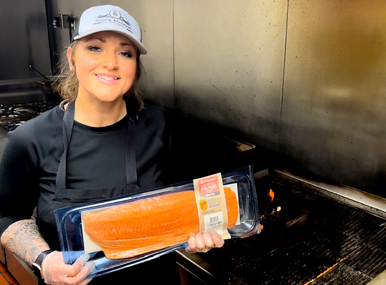 Chandra poses with a package of salmon sourced from Sam's Club.