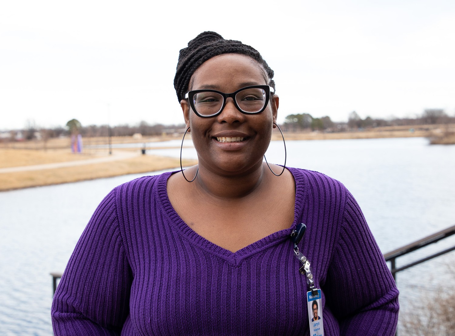 Woman smiling at the camera in front of a lake