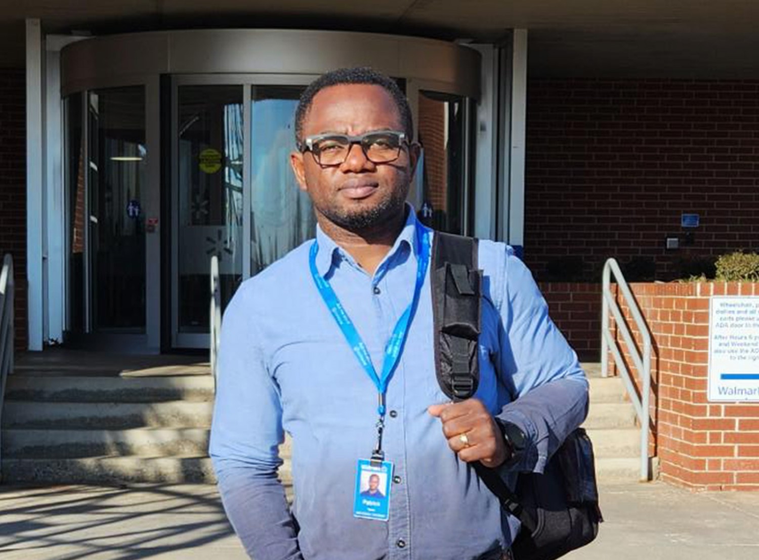 man smiling at the camera in front of the Walmart Home Office entrance