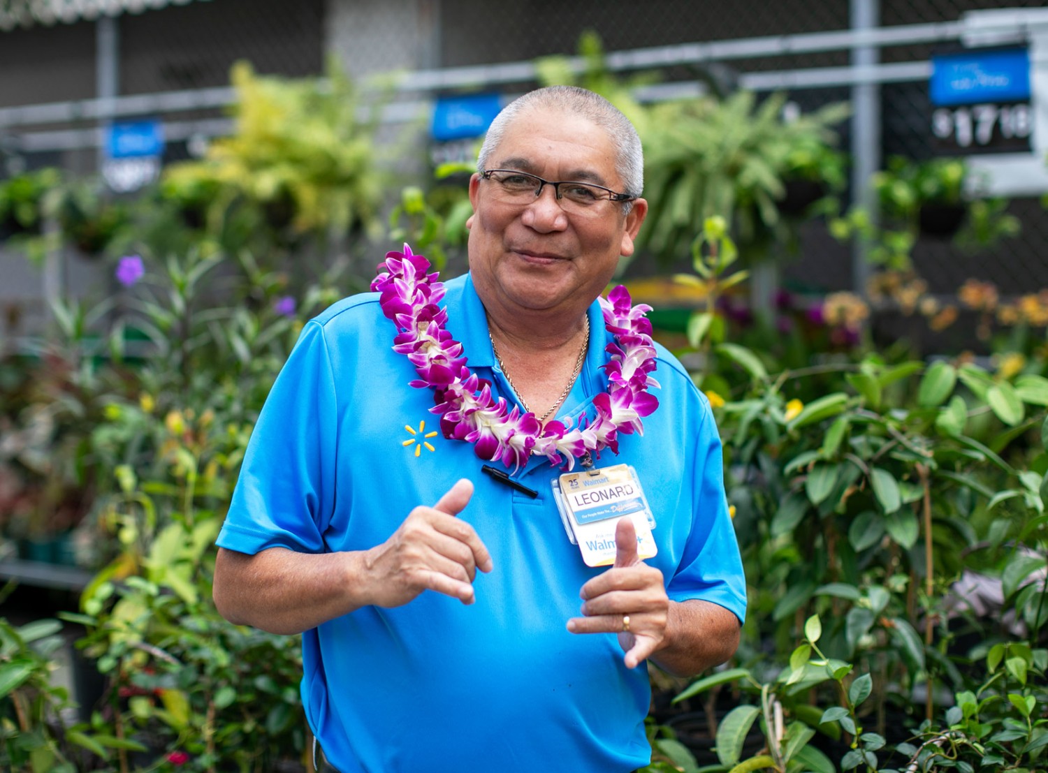 Male associate smiling at the camera in the garden area of Walmart