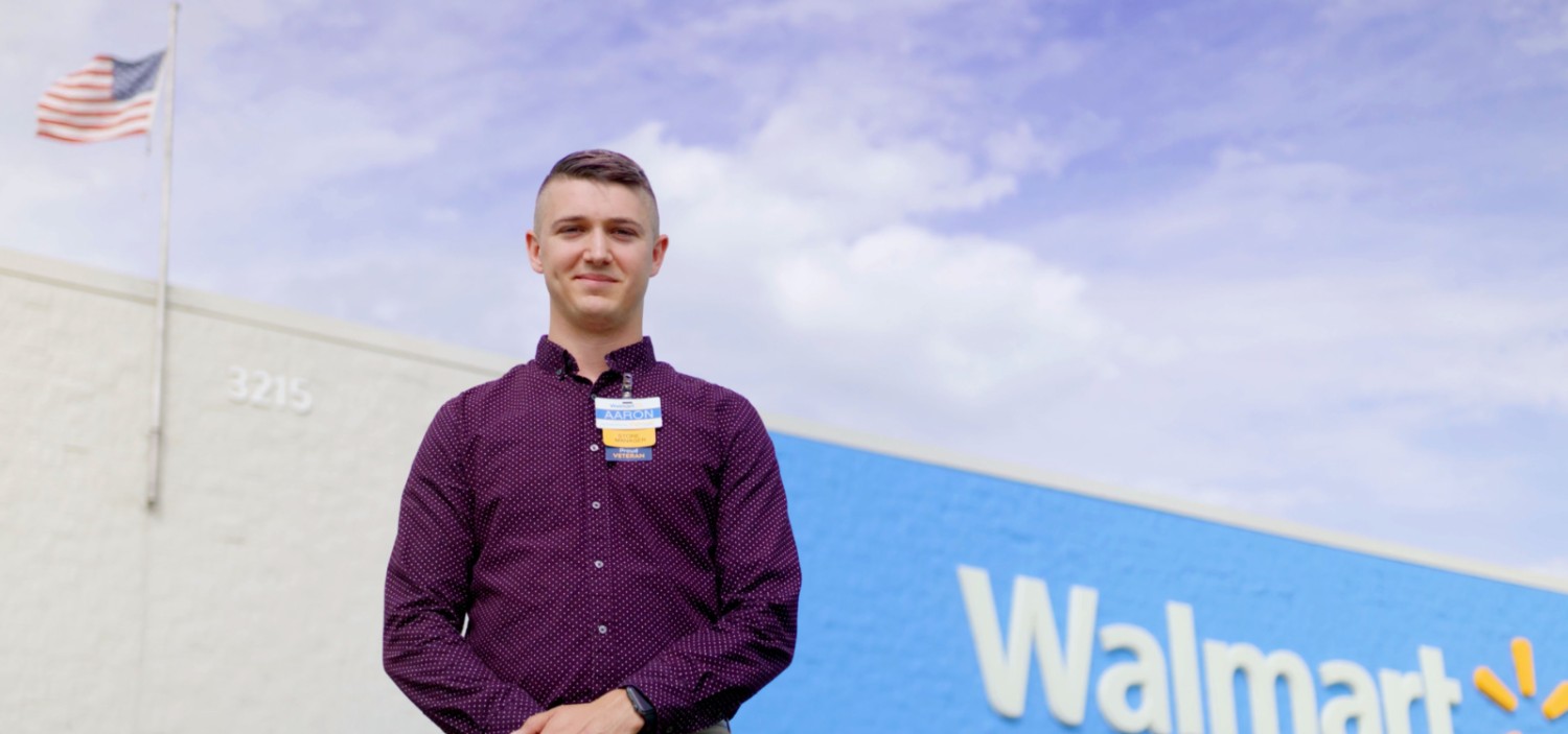 Aaron standing in front of a Walmart super center store front
