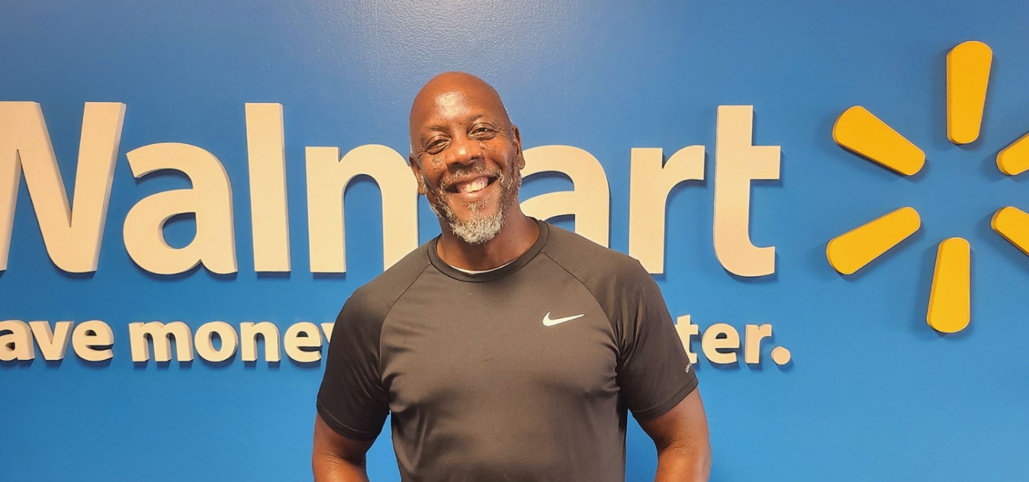 Lewis smiling in front of a Walmart sign