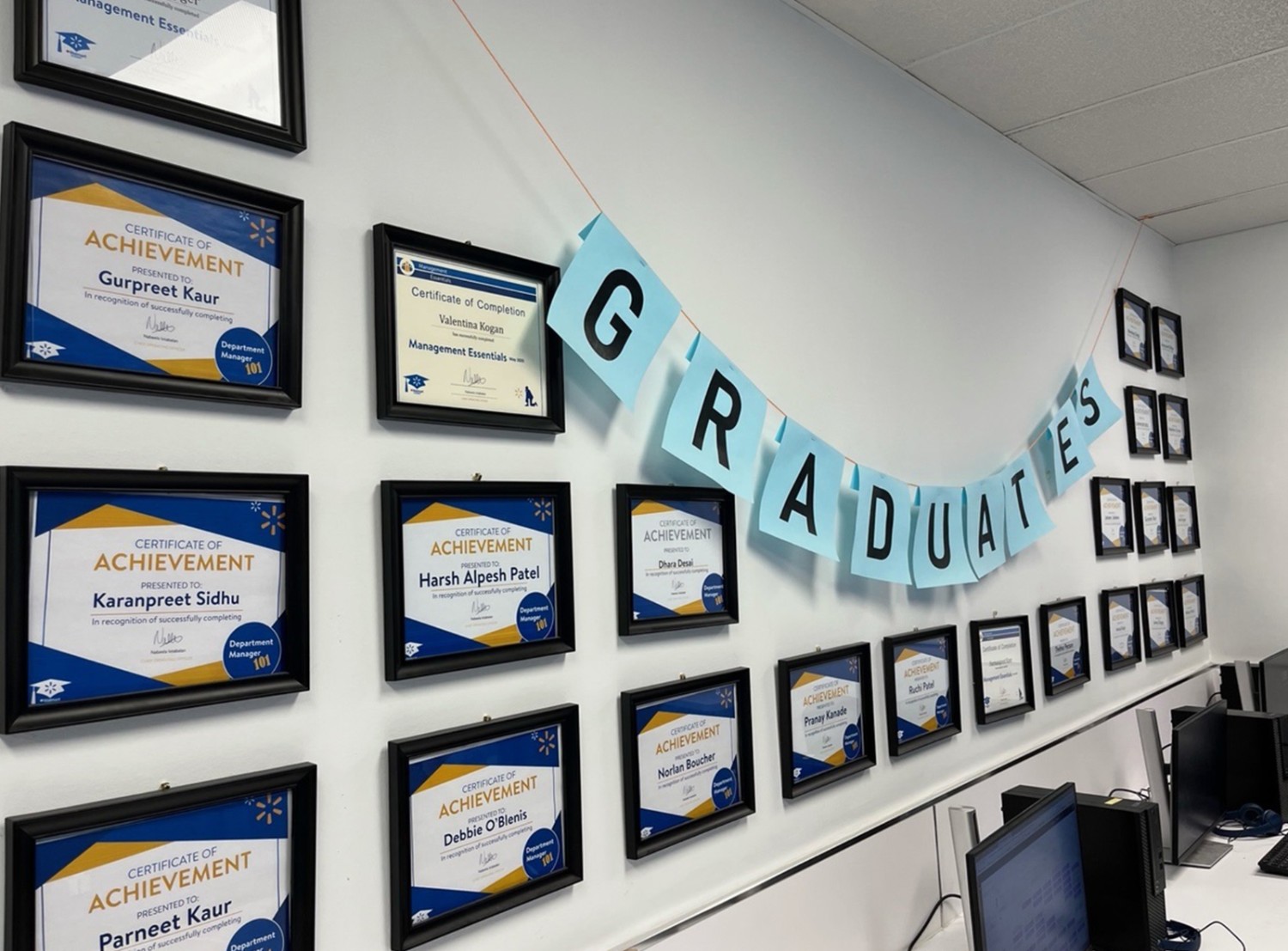 wall with framed diplomas and a graduate banner hanging on the wall