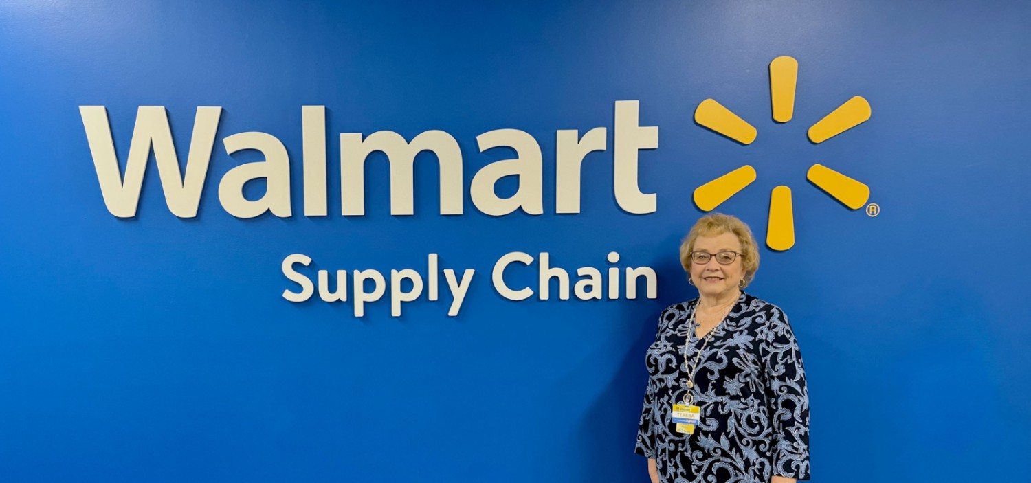 Teresa Stewart standing in front of a Walmart Supply Chain sign