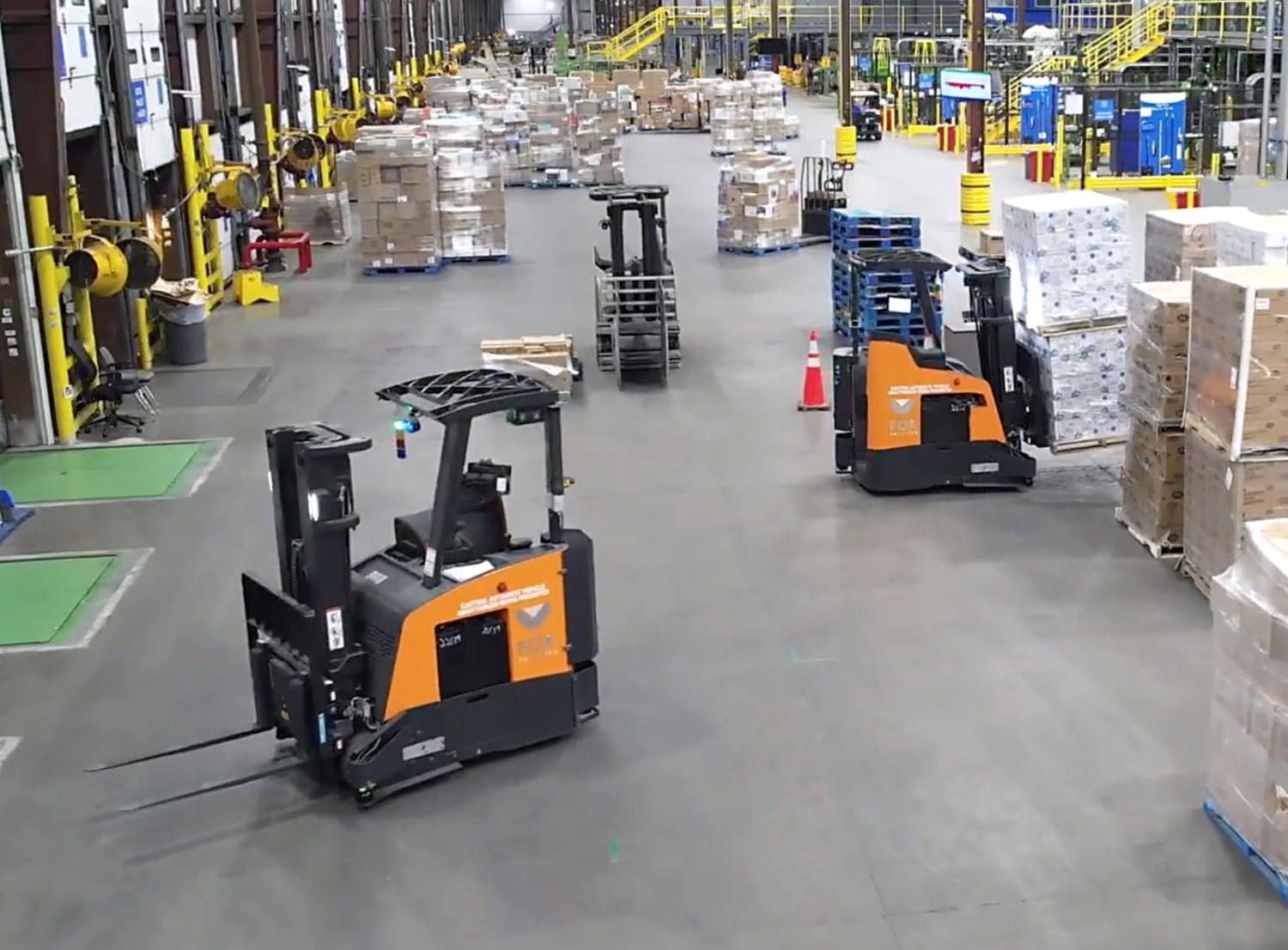 forklift machines at a distribution center surrounded by boxes