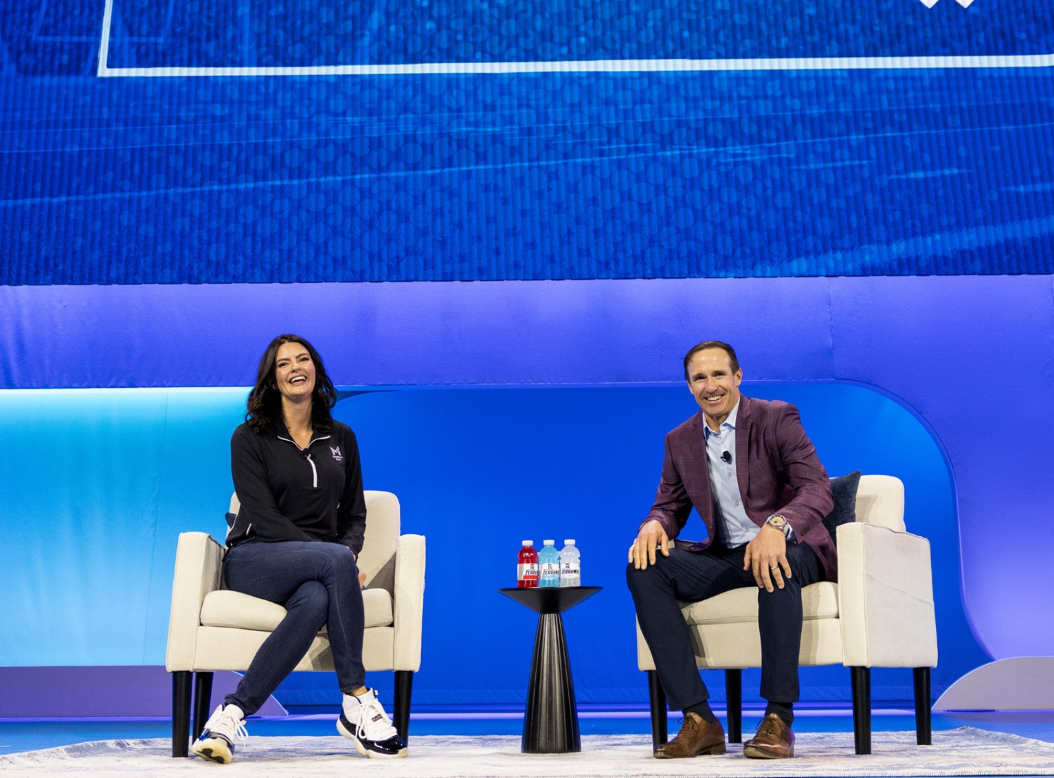Diana Marshall and Drew Bress sitting on stage smiling at the camera
