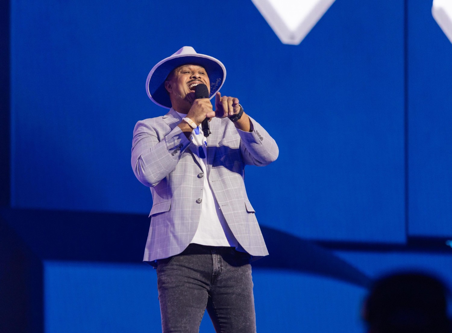Cedric Clark on stage holding a microphone