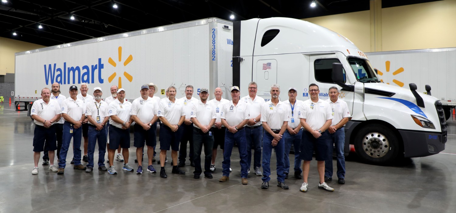 A group of Walmart truck drivers posing in front of a Walmart truck