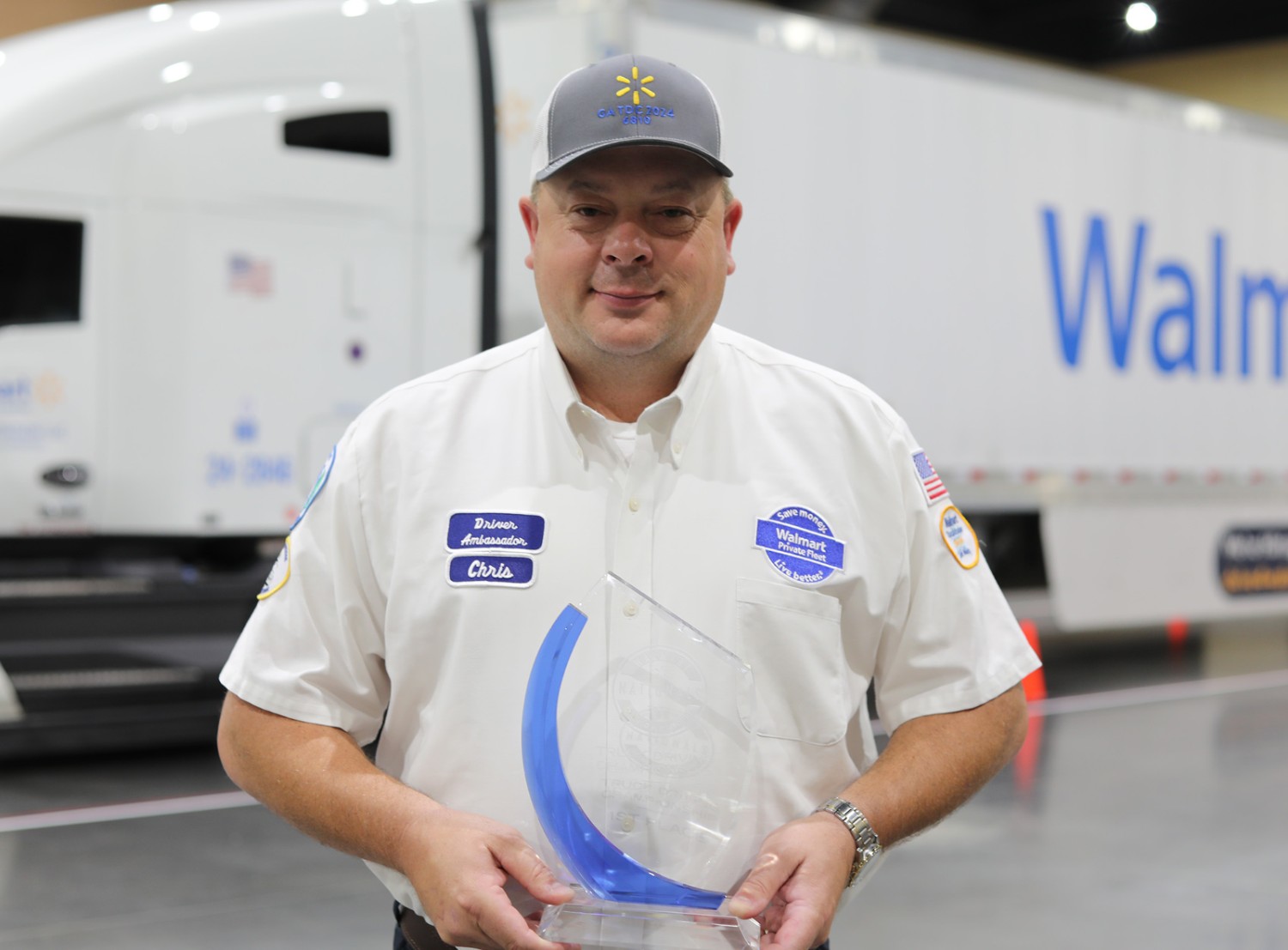 A Walmart driver posing with a trophy