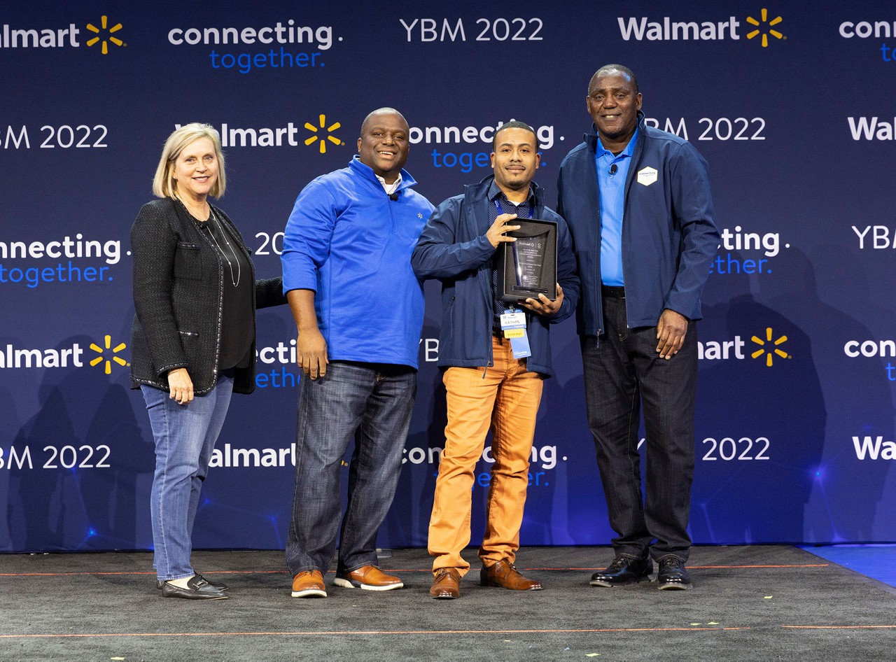 Kathan Morgan receives the Helen R. Walton Excellence in Community Leadership award; he is standing with other Walmart associates.