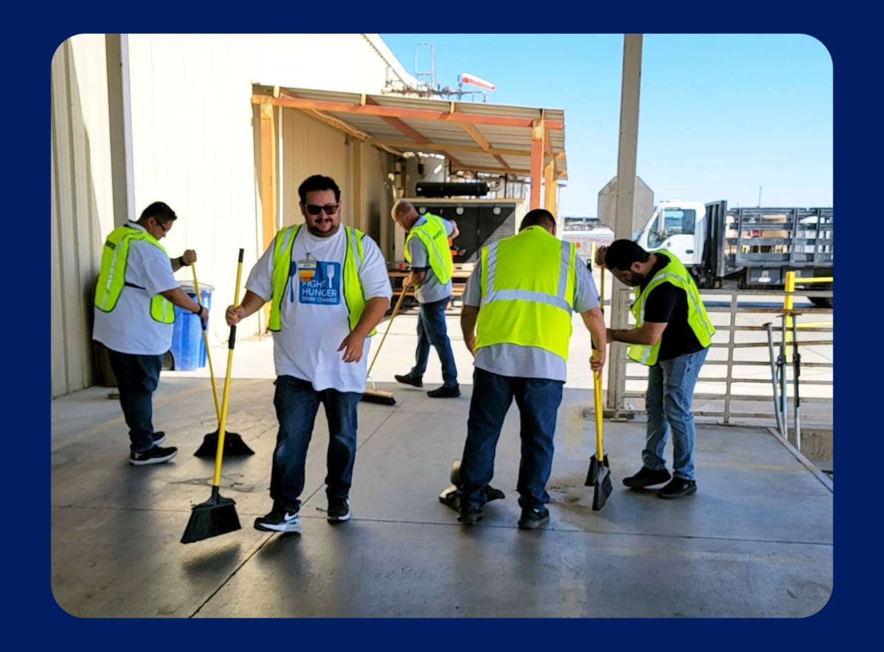 Walmart associates volunteer at the Yuma Food Bank, sweeping the ground.
