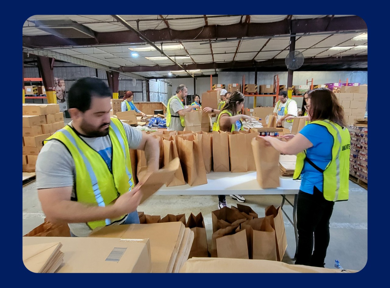 Walmart associates pack brown bags with donated food.
