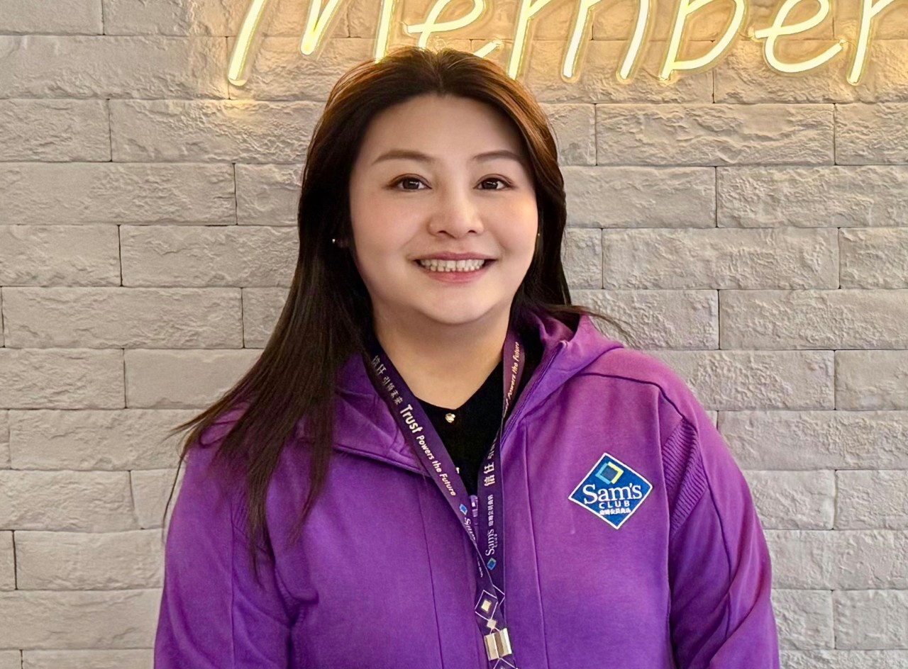 Associate Feng Bi Jia wears a Sam’s Club shirt and lanyard and smiles.