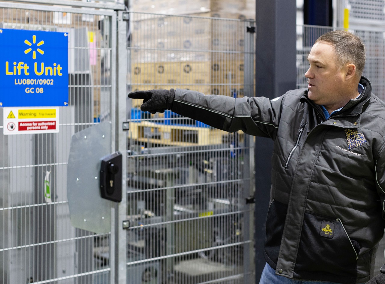 Walmart associate James Bright watches boxes on conveyer.