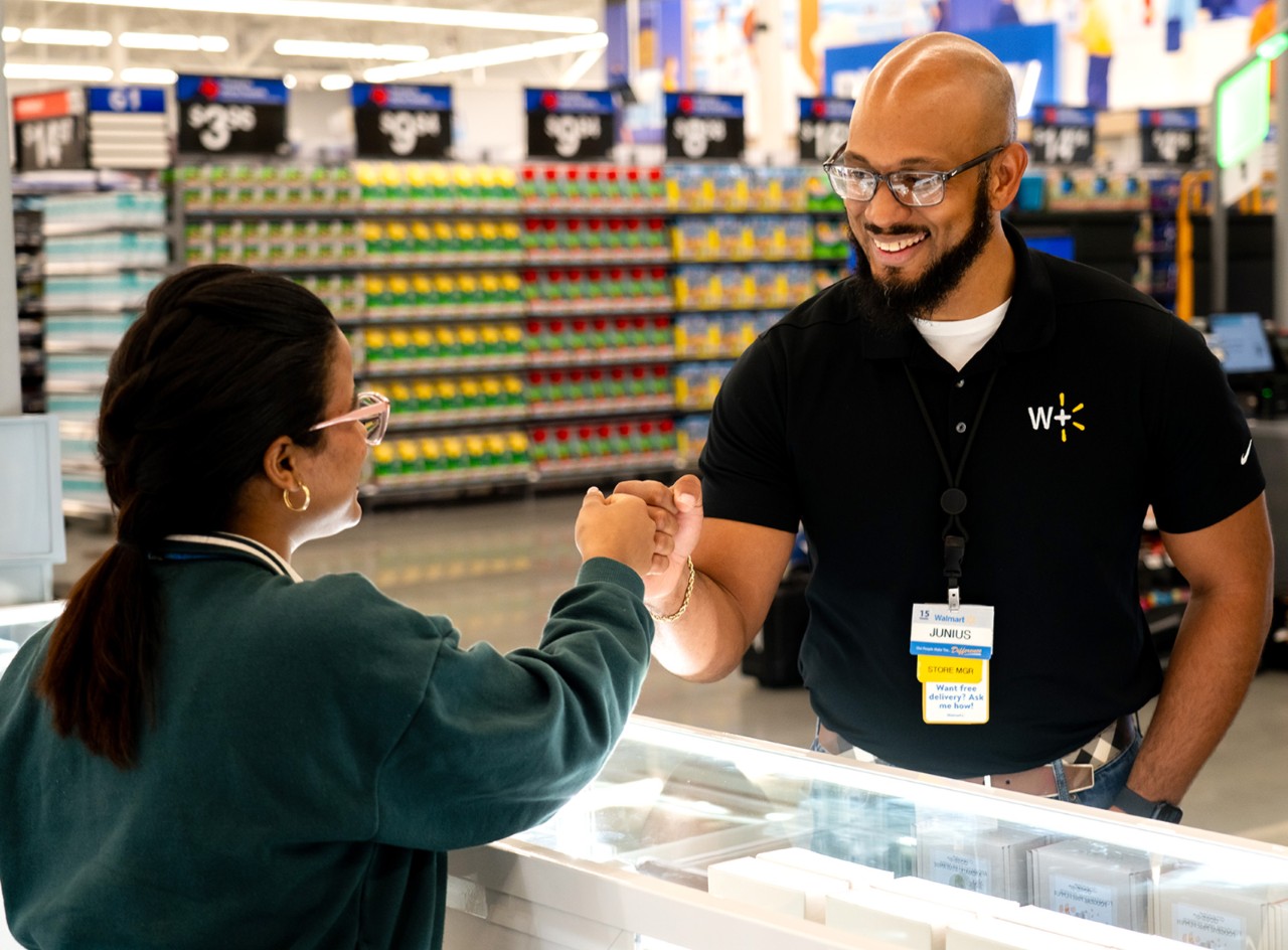Store Manager Junius Williams fist bumps another Walmart associate.