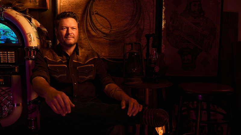 Cover art from Blake Shelton's album, For Recreational Use Only. In an old honky-tonk, with cowboy paintings on the walls, Blake sits in front of a retro jukebox.