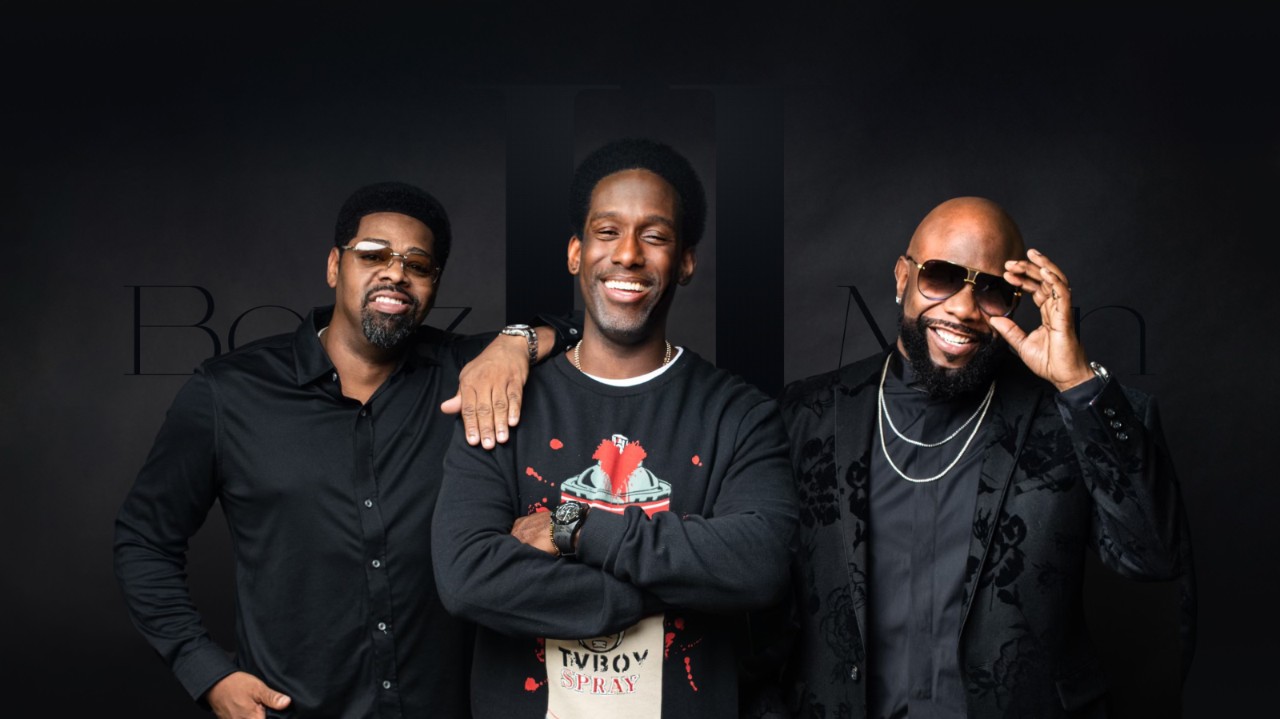 Recording artists Boyz II Men pose together against a dark background.